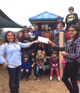 Papermill Creek Children's Corner director Lourdes Romo receives the grant from the 8th grade class!